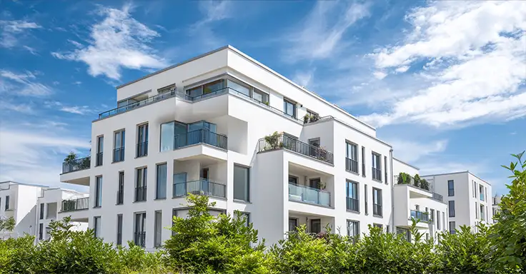 Maklerin zeigt Mietinteressenten eine Wohnung